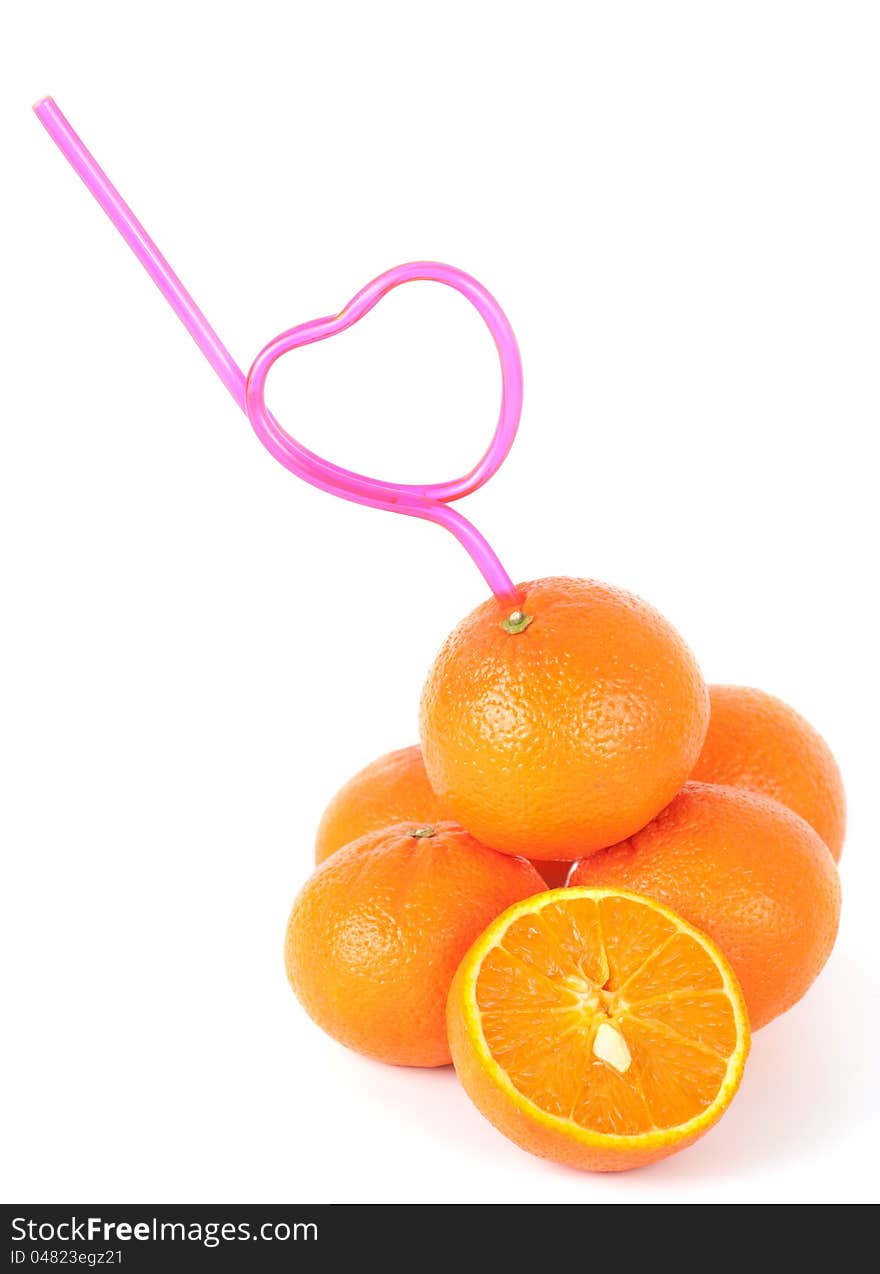 Concept of loving fresh mandarin juice with a straw bent in the shape of a heart inserted into a pile of fresh mandarins. Concept of loving fresh mandarin juice with a straw bent in the shape of a heart inserted into a pile of fresh mandarins