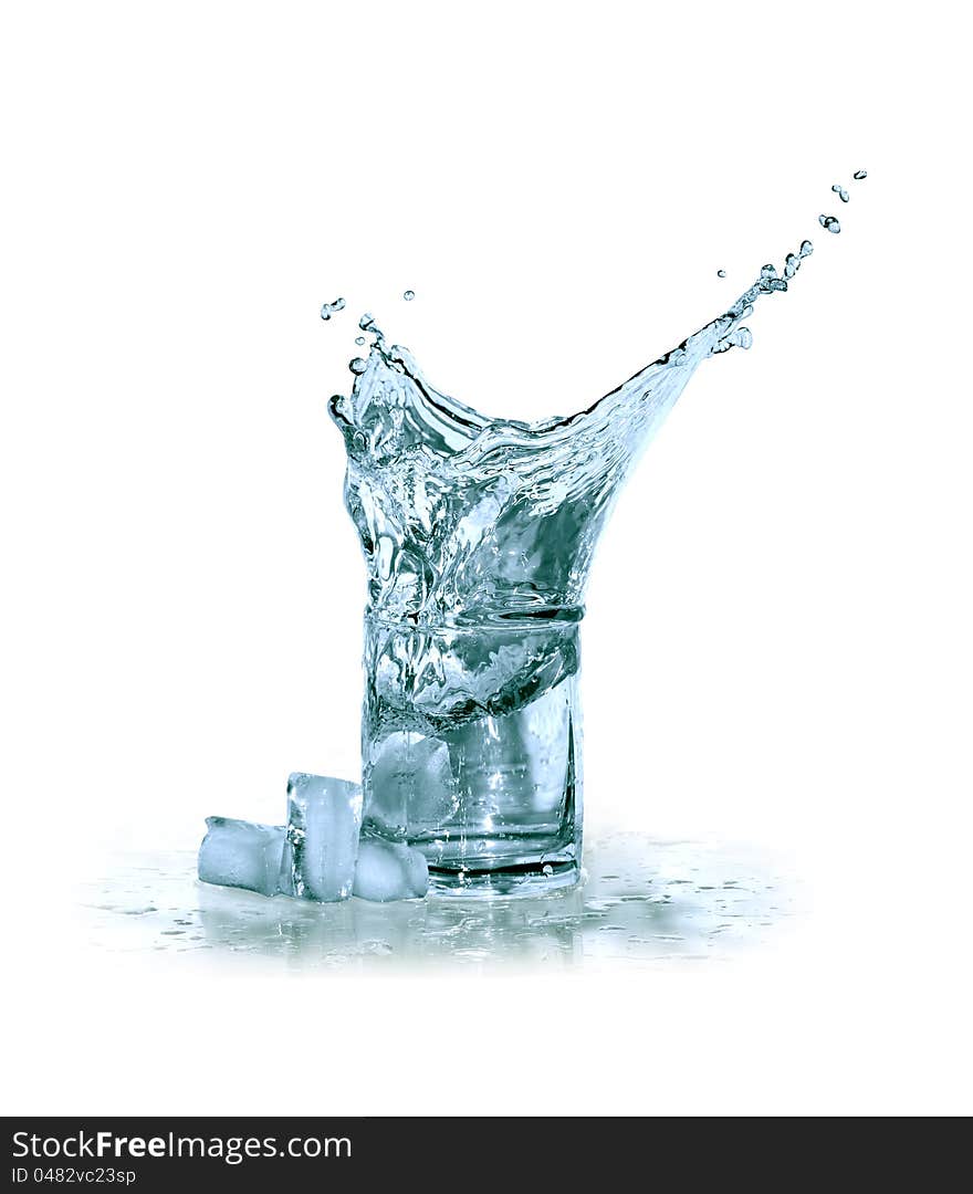 Glass of splashing water near ice cubes on white background. Clipping path is included. Glass of splashing water near ice cubes on white background. Clipping path is included