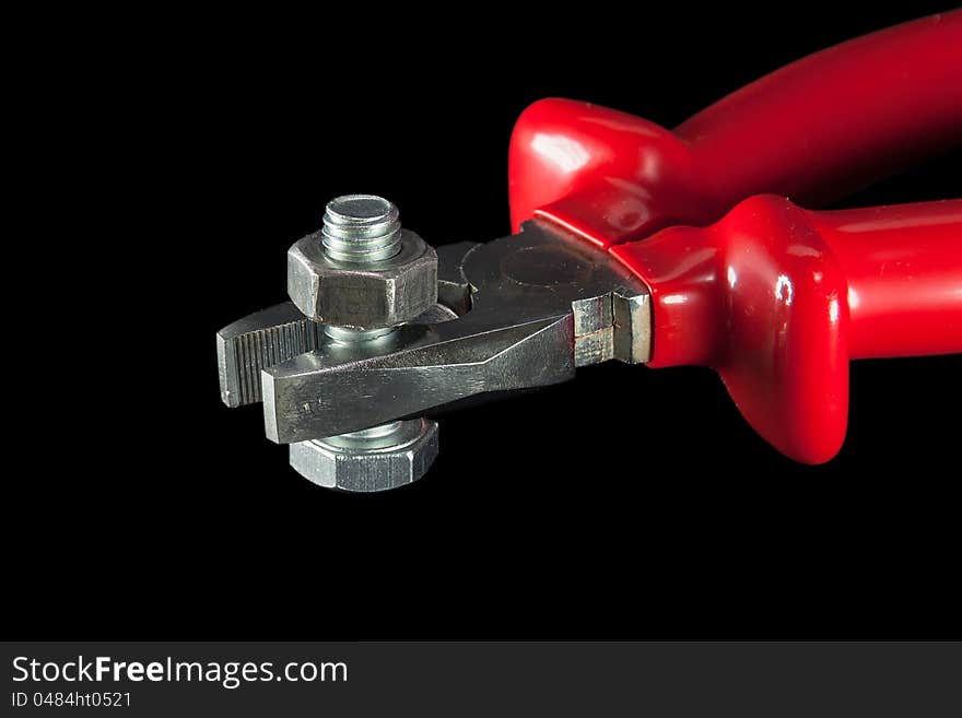 Combination pliers with bolt and nut on a black background macro