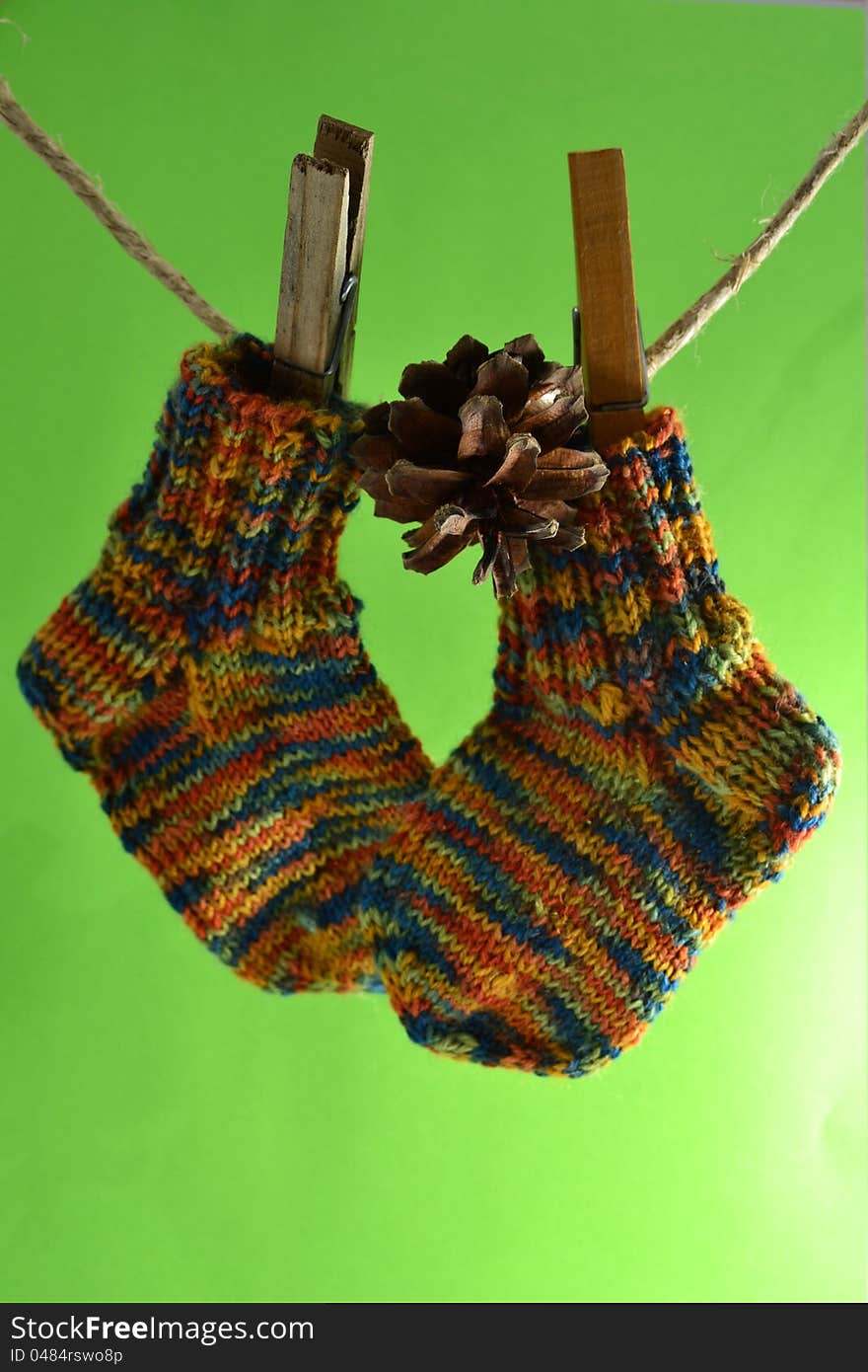 Wool socks for little kids hanging on the washing line also a pine cone. Wool socks for little kids hanging on the washing line also a pine cone