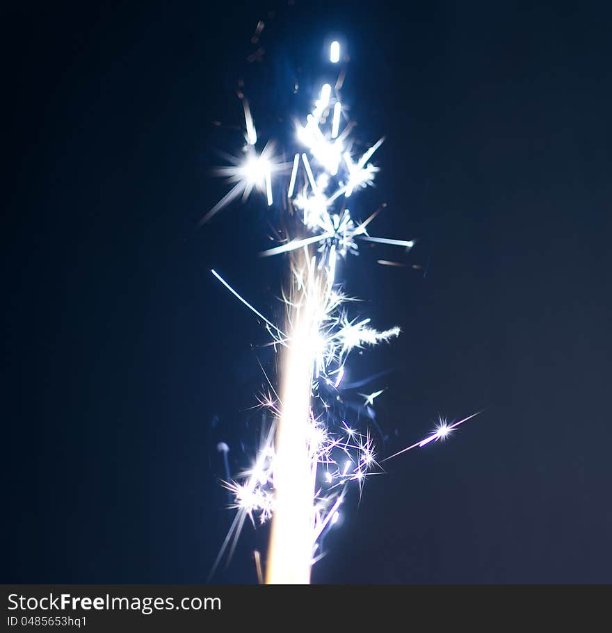 Burning firework on blue background