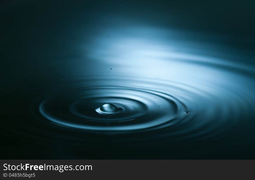 Splash of water drop closeup in blue tonality. Splash of water drop closeup in blue tonality