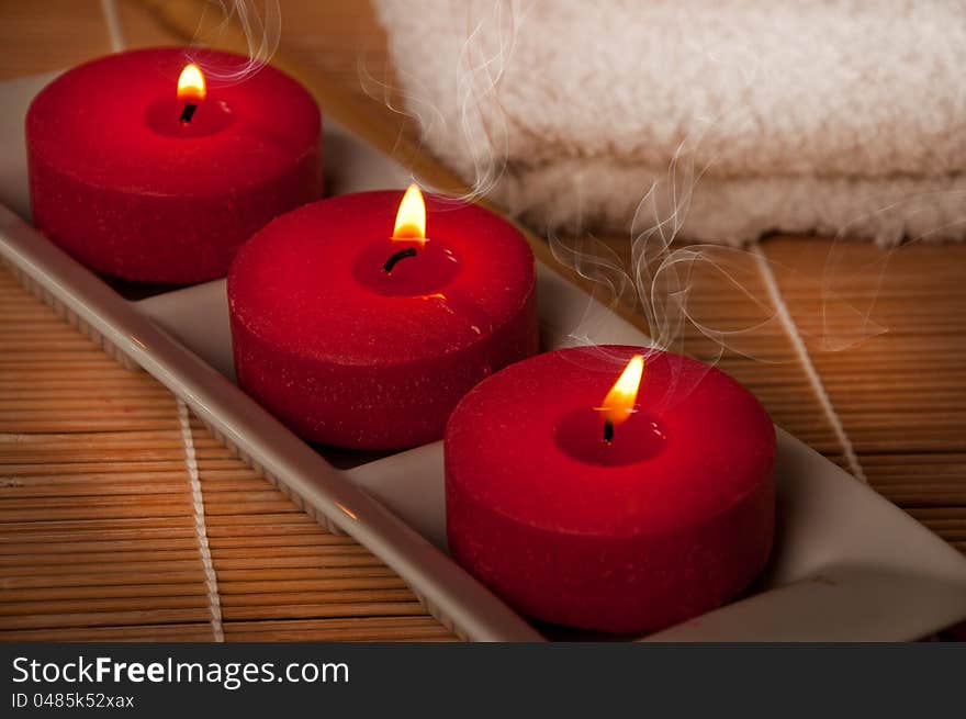 Three scented candles on bamboo mat. Three scented candles on bamboo mat