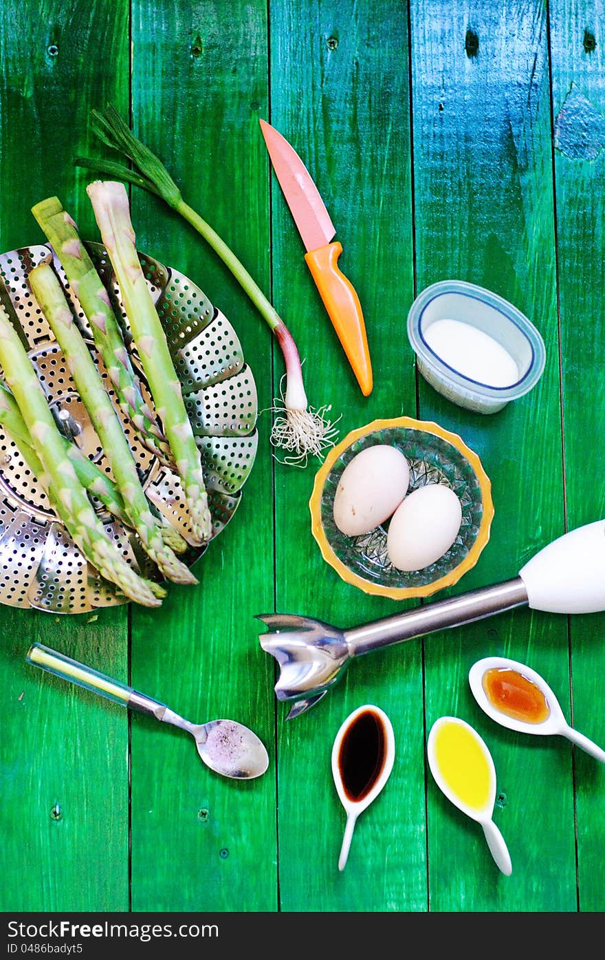 Asparagus soup ingredients and kitchen wear on a green table. Asparagus soup ingredients and kitchen wear on a green table