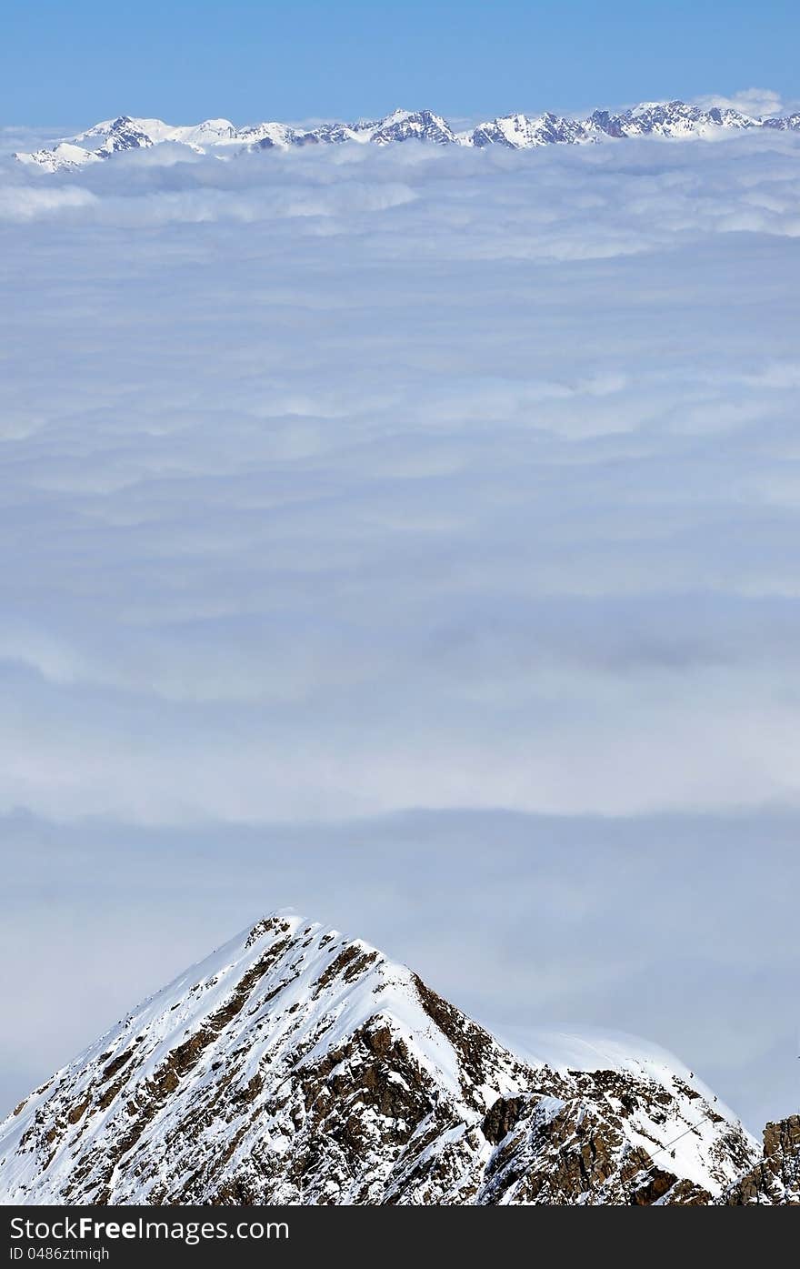 Clouds and fog above, winter landscape in the Alps