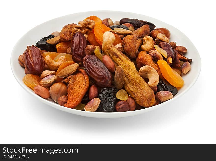 Mixed dry fruits on a plate against white background