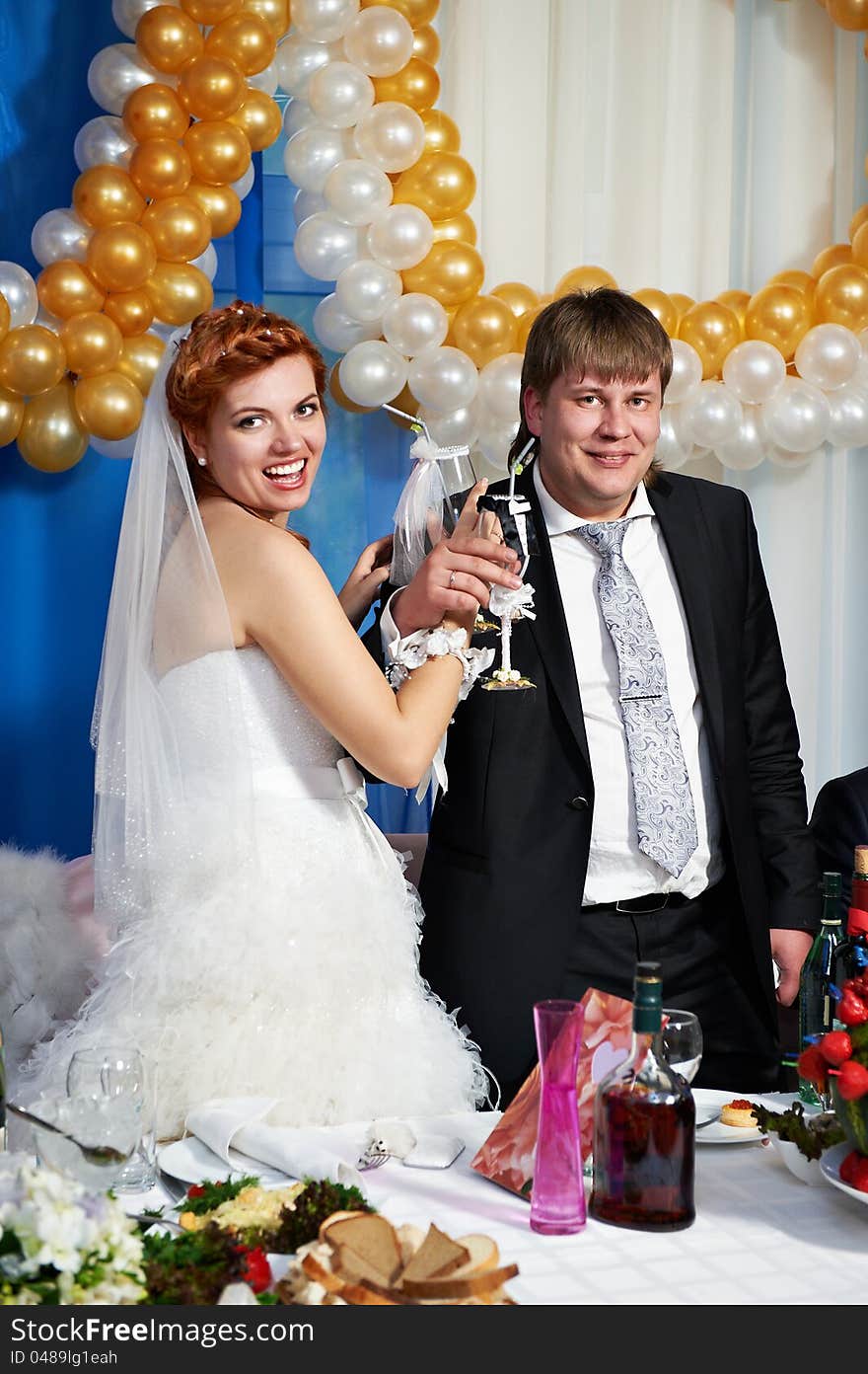 Happy bride and groom with champagne glasse in banquet