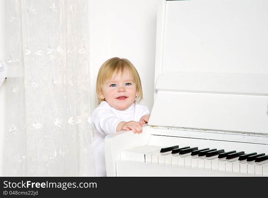 Girl sitting next to a white piano