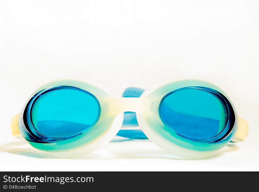 Blue swimming goggles against a white grey background