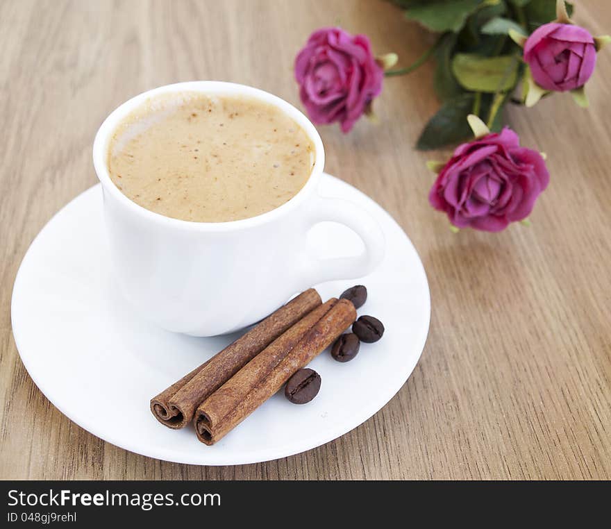 Cup of cappuccino with cinnamon and coffee beans