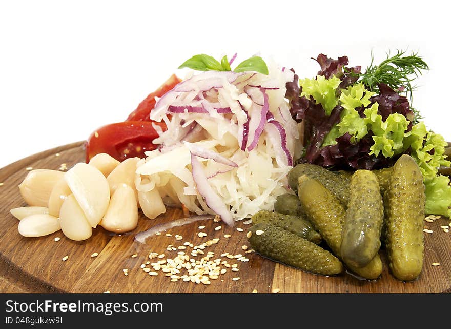 Wooden plate with pickles on a white background. Wooden plate with pickles on a white background