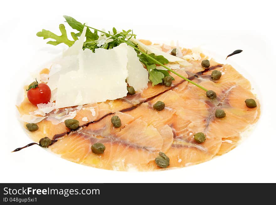 Slices of salmon with herbs and cheese on a white plate