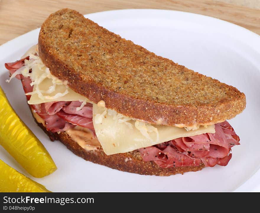 Grilled reuben sandwich with pastrami and swiss cheese on a plate