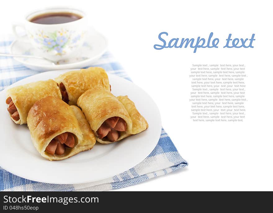 Sausage in the dough on a plate and cup of tea on white background with sample text