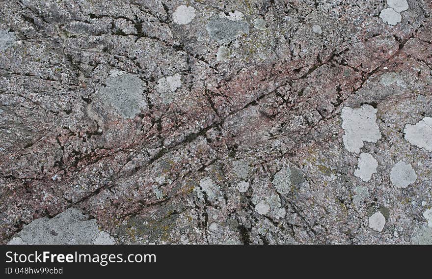 The surface of the granite stone with patches of lichens. Can be used as background