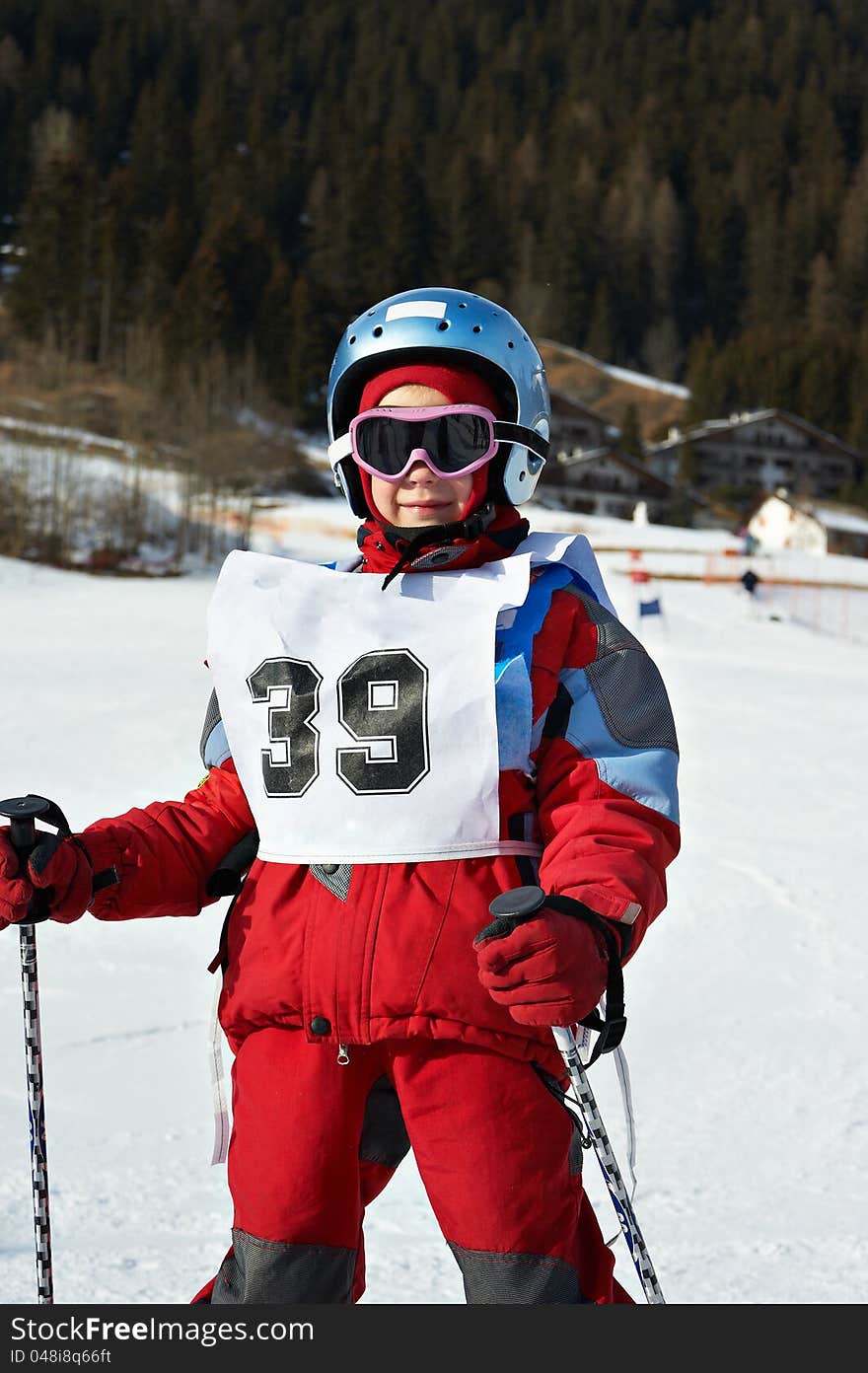 Child on helmet and with sports number  in the ski resort. Child on helmet and with sports number  in the ski resort