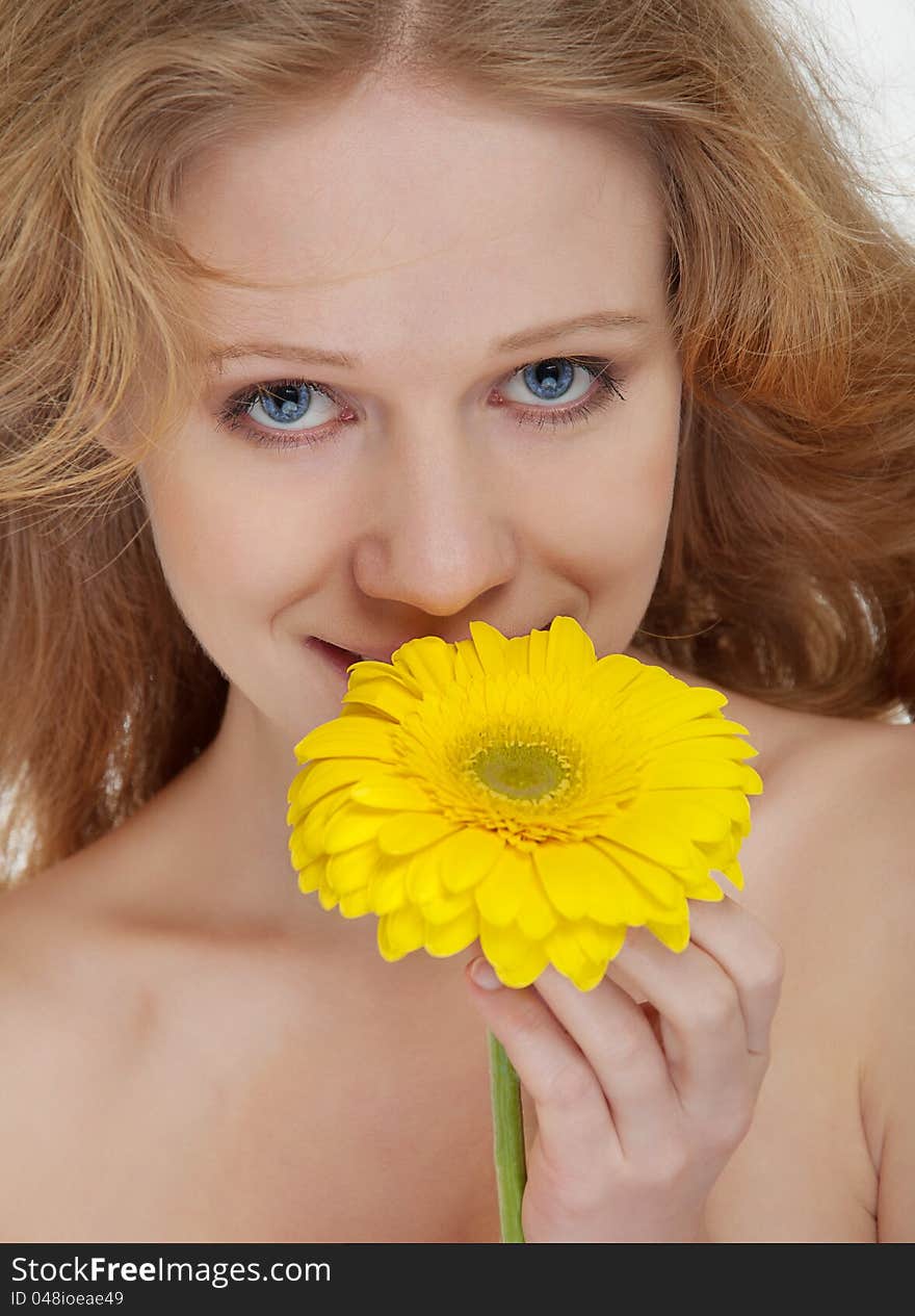 Beautiful blonde girl with yellow gerbera flower