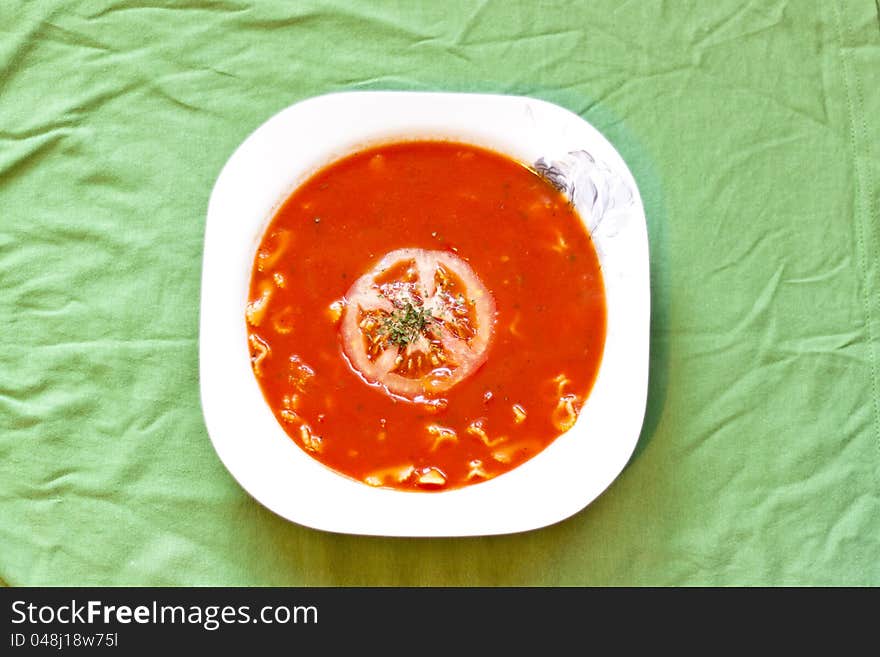 Beauty and tasty tomato soup on green tablecloth. Beauty and tasty tomato soup on green tablecloth.