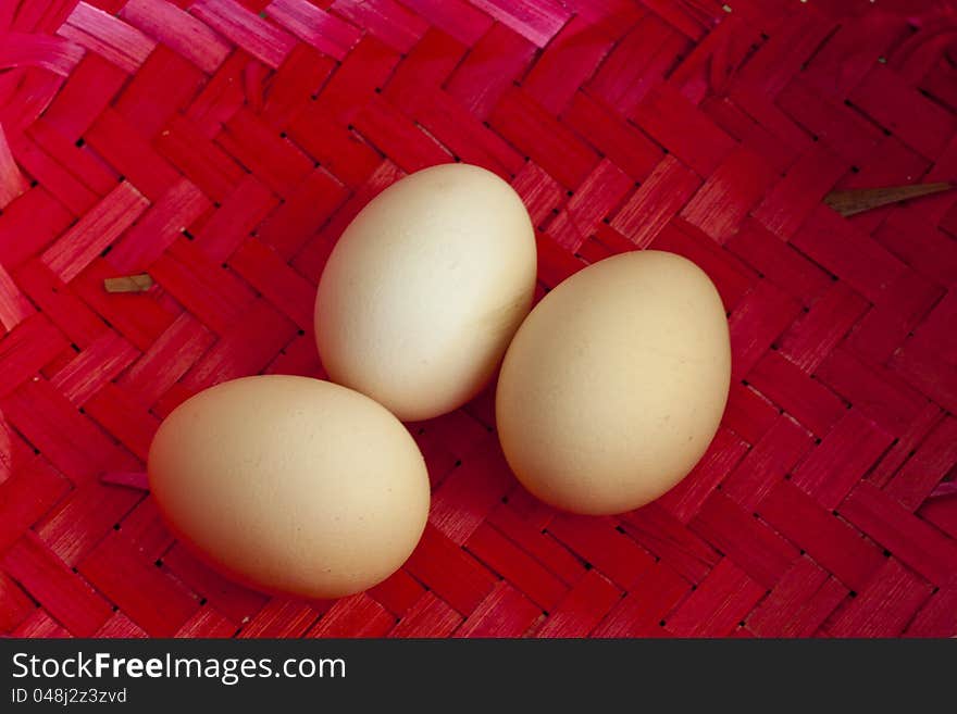 Three big ecological chicken eggs in red wicker basket. Three big ecological chicken eggs in red wicker basket.