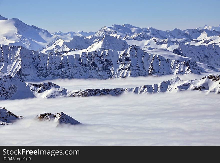 Peaks above clouds, winter in the Austrian Alps. View from Kitzsteinhorn, Kaprun.