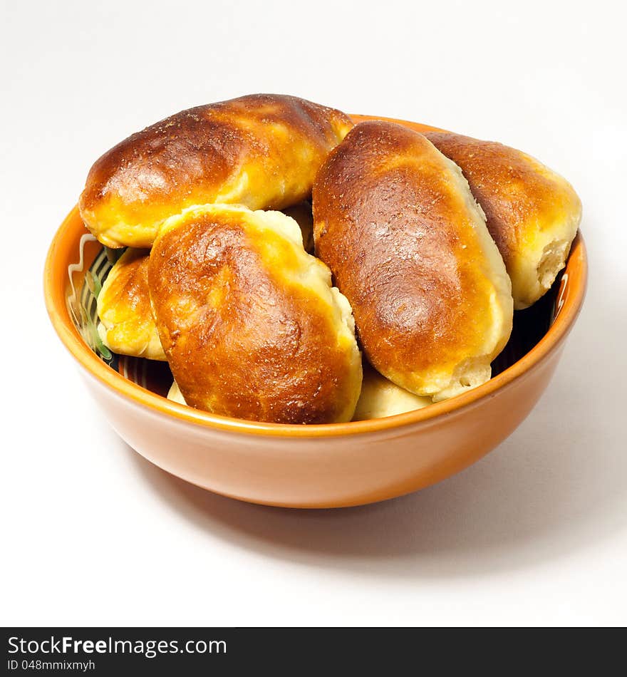 Pies in a clay plate on a white background