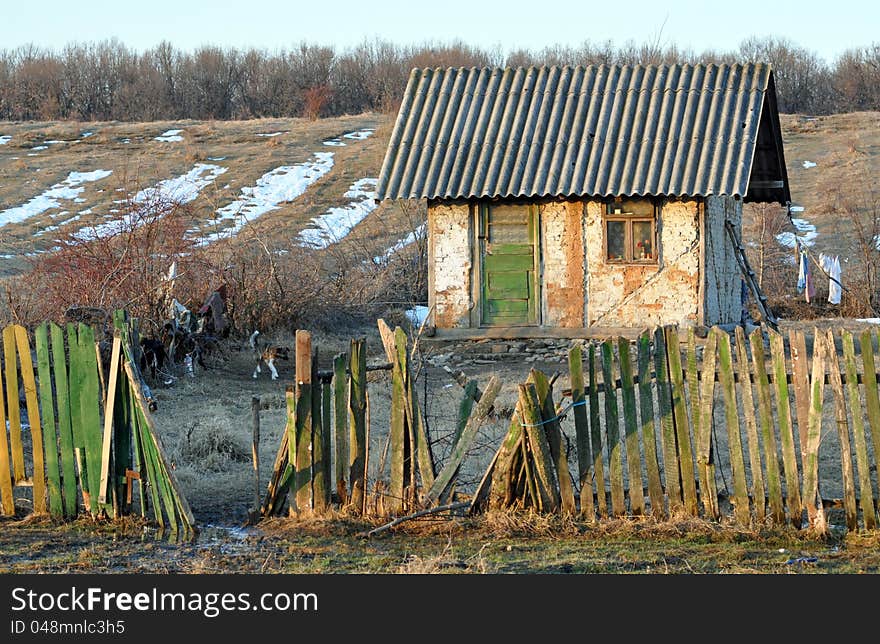 Isolated poor house with damaged fence