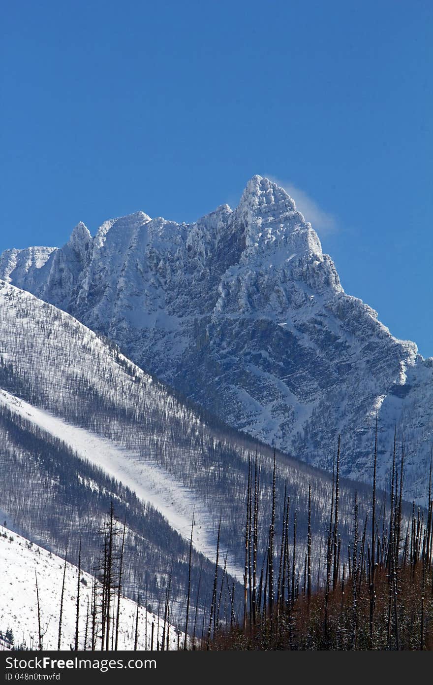 This image of the rugged mountain peak with the wind blowing snow off the summit was taken in Glacier National Park, MT. This image of the rugged mountain peak with the wind blowing snow off the summit was taken in Glacier National Park, MT.