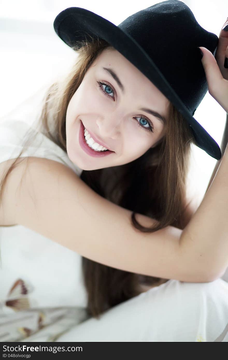 Portrait of a smiling brunette woman wearing a black retro hat. Portrait of a smiling brunette woman wearing a black retro hat