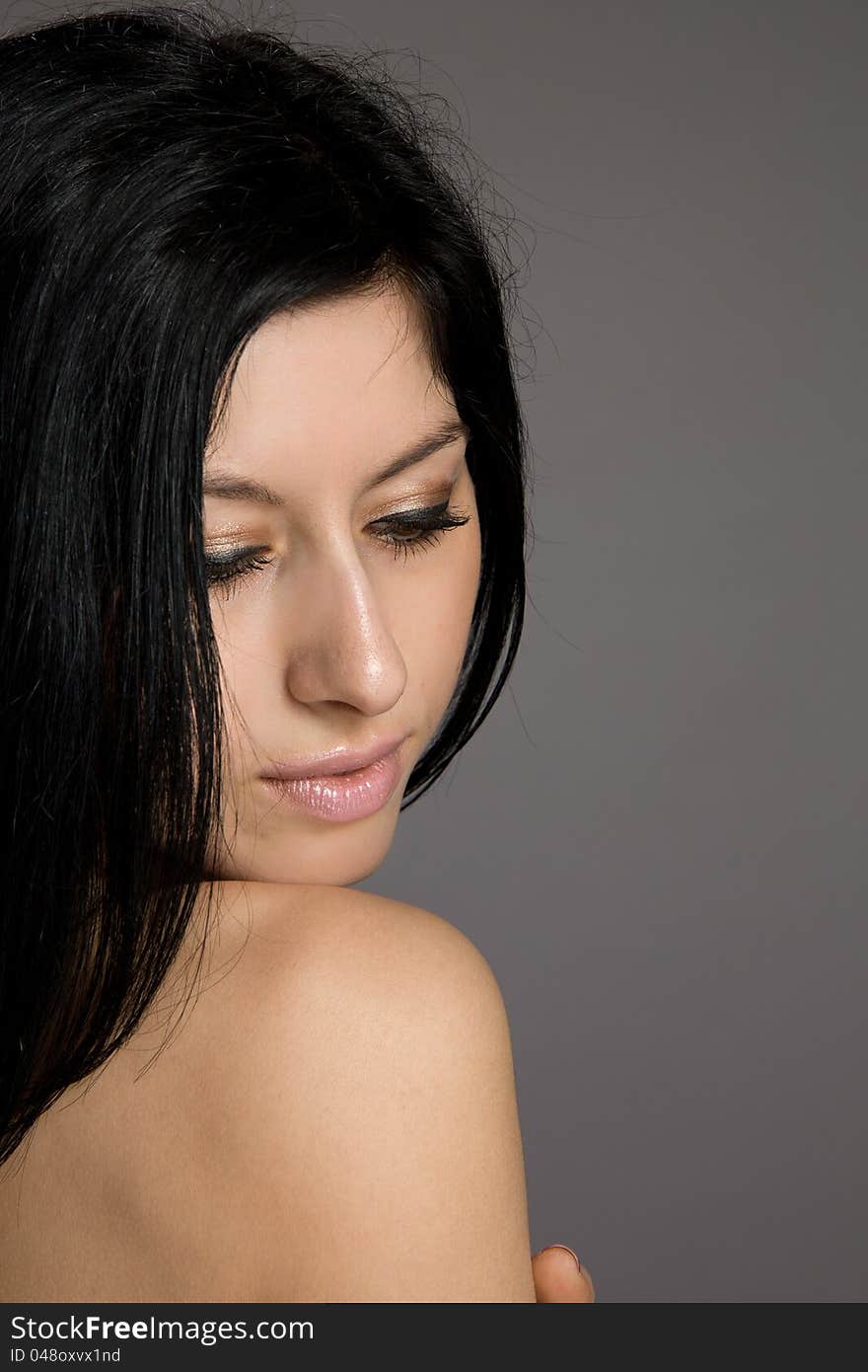 Portrait of beautiful brunette on a gray background. Portrait of beautiful brunette on a gray background