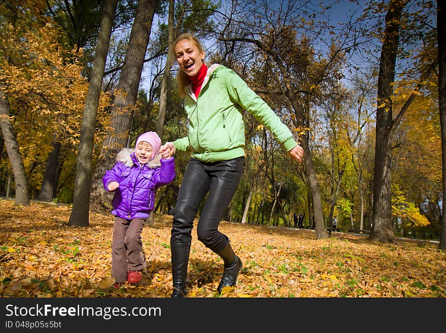 Woman  with her daughter in the autumn park