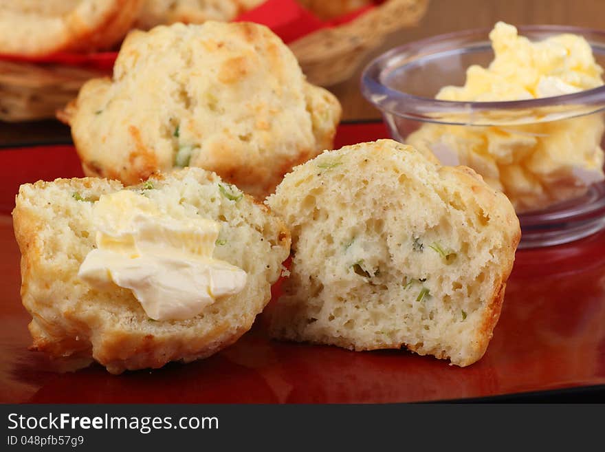 Biscuits with one cut in half with butter on a plate. Biscuits with one cut in half with butter on a plate