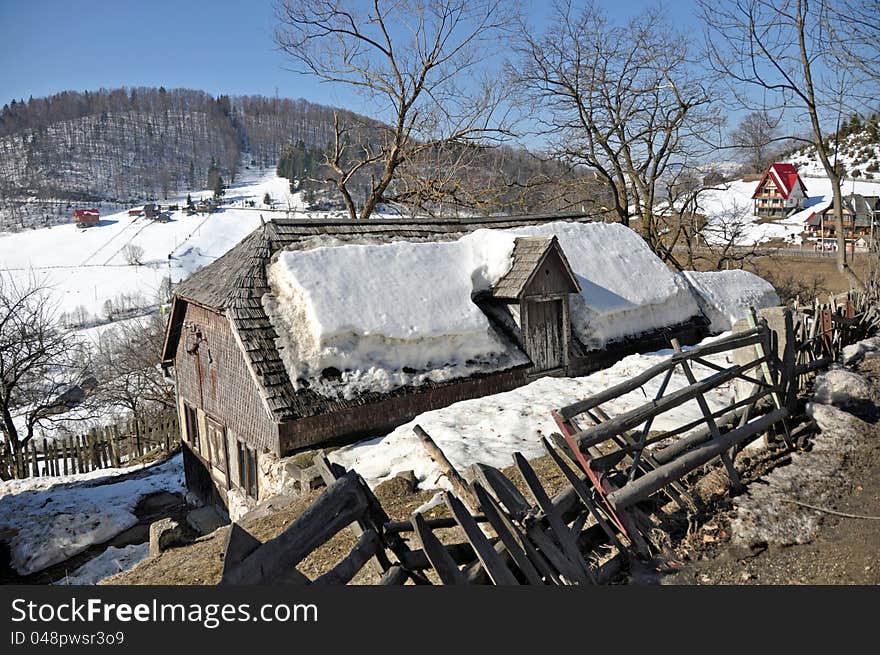 Wooden house covered by snow in mountain valley near Transylvania land of Romania, at Rucar Bran resort. Wooden house covered by snow in mountain valley near Transylvania land of Romania, at Rucar Bran resort