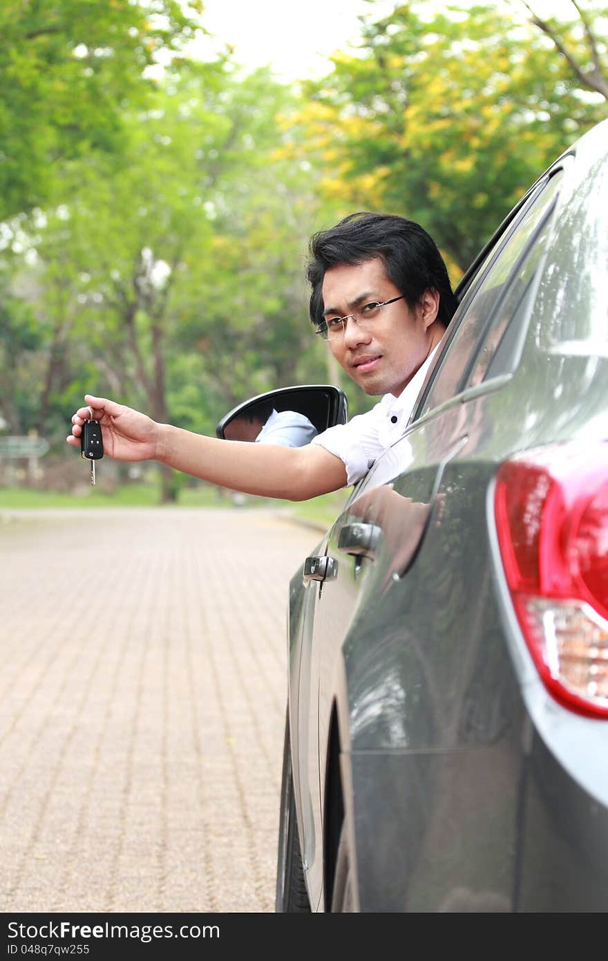 Young man in the car show the key