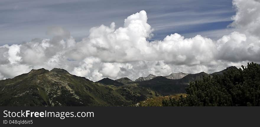 Alpine landscape panorama: mountain peaks and beautiful cloudy sky in Obertauern area, Austrian Alps, Europe. Alpine landscape panorama: mountain peaks and beautiful cloudy sky in Obertauern area, Austrian Alps, Europe