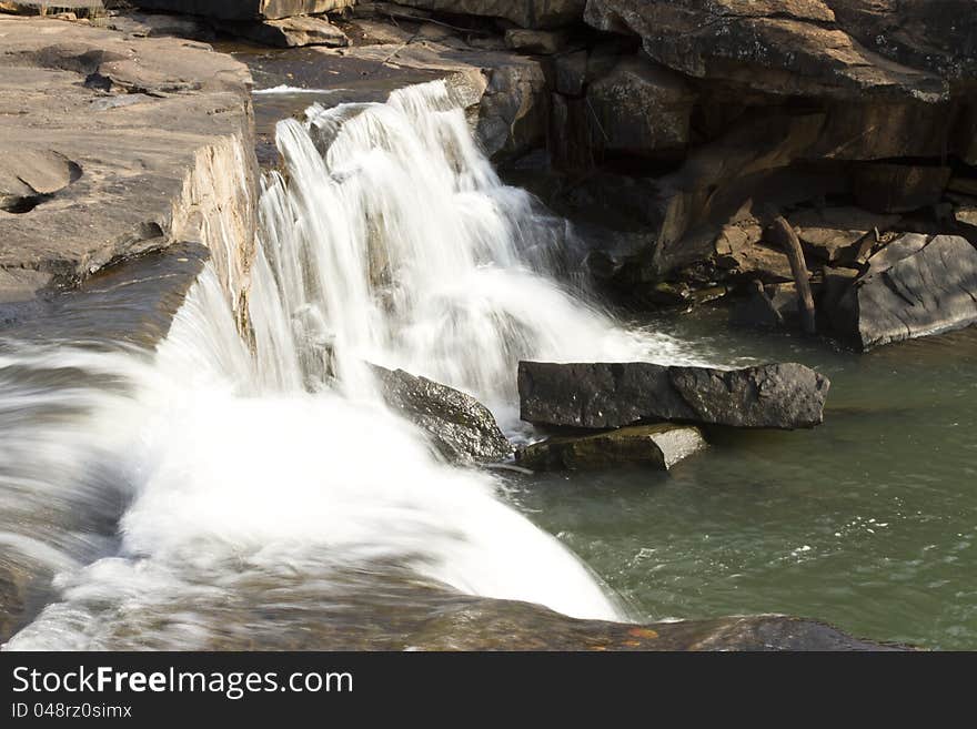 Rock mountain with flowing waterfall.