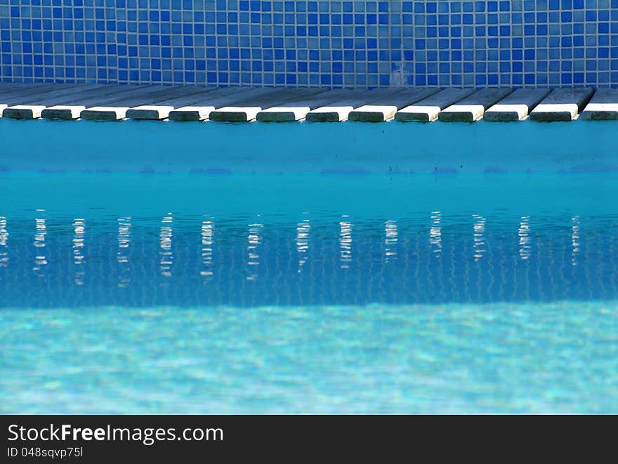 Swimming pool border reflected on water