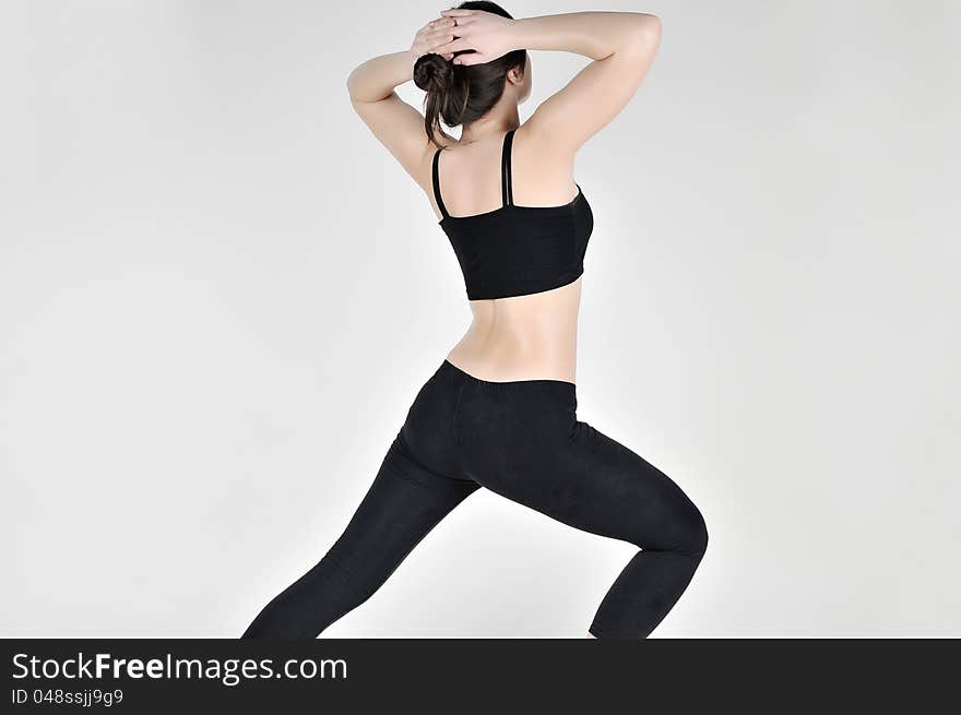 Sports girl doing exercises in a black tracksuit