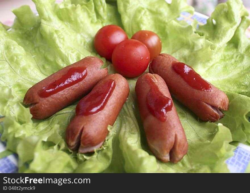 Cooked sausage with lettuce and tomatoes cherry