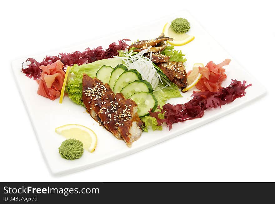 Fish and eel salad with vegetables on a white background. Fish and eel salad with vegetables on a white background