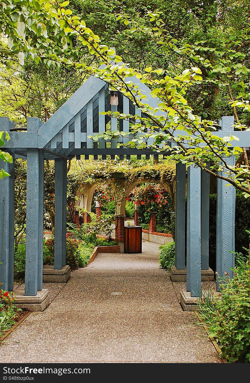 Blue wooden arch over botanical garden path