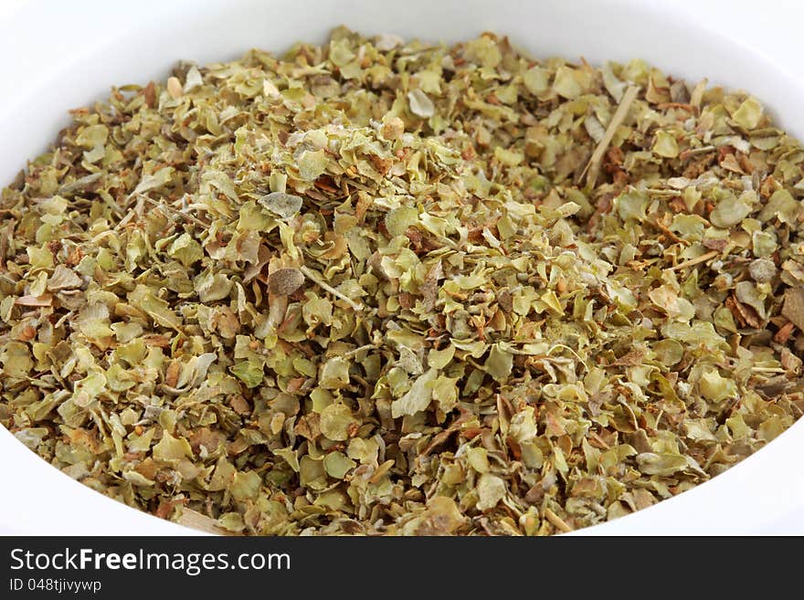 Closeup photo of a bowl of dried aromatic herb : Sweet Marjoram spice. Closeup photo of a bowl of dried aromatic herb : Sweet Marjoram spice