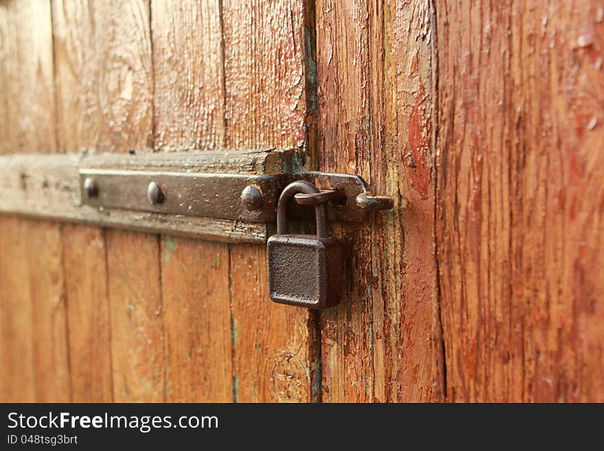 The old rusty lock on a wooden door. The old rusty lock on a wooden door.