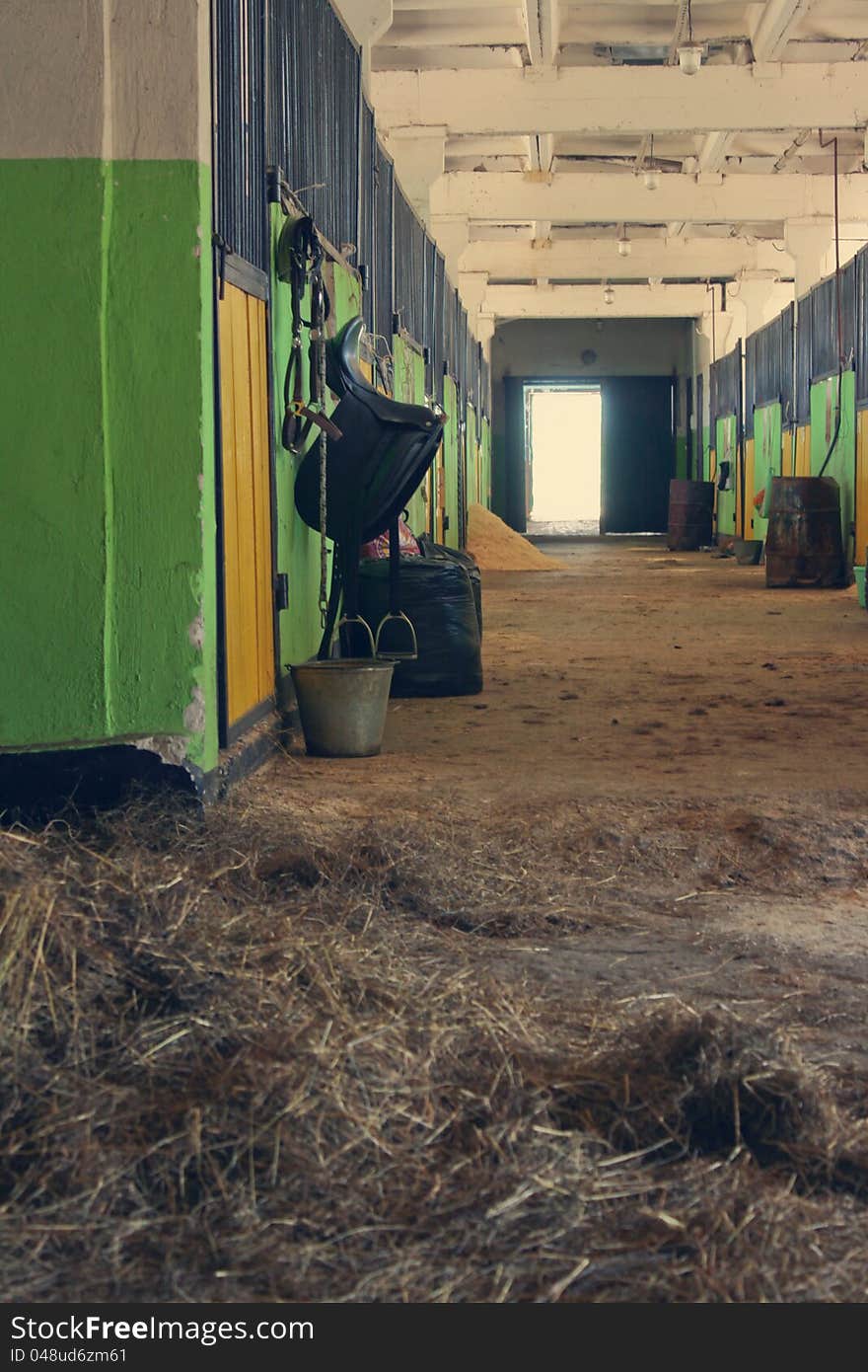 Passage of the stable, saddle, hay and a bucket with water. Passage of the stable, saddle, hay and a bucket with water