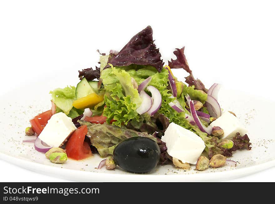 Greek salad on a plate on a white background