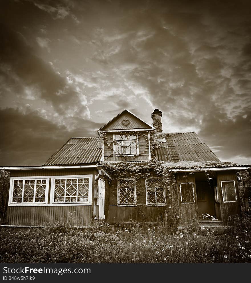 An old, abandoned house, yard, overgrown with grass, evening, at sunset. An old, abandoned house, yard, overgrown with grass, evening, at sunset