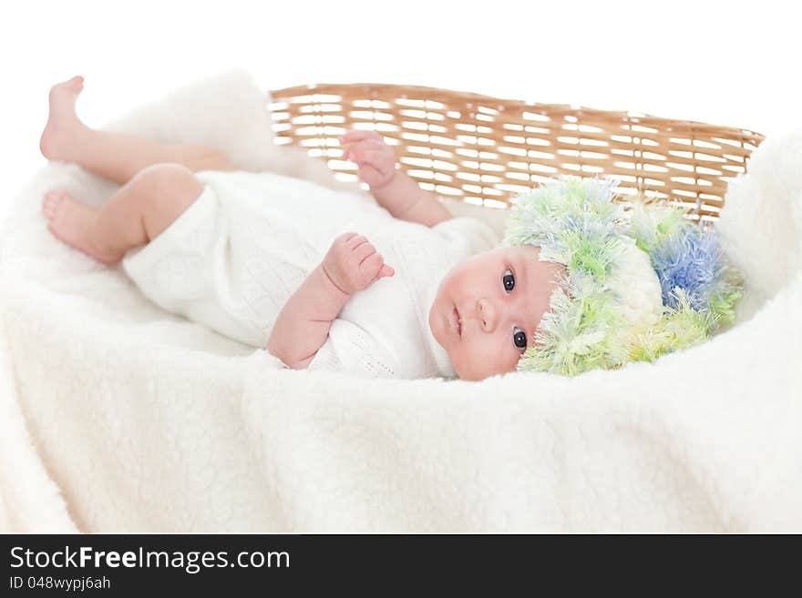 Newborn baby weared a cap in a wicker basket