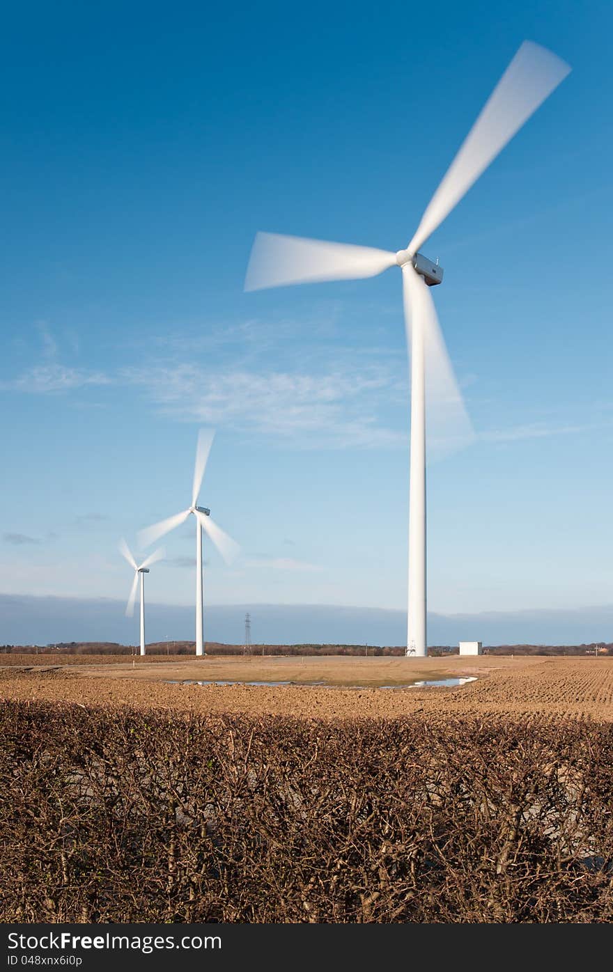 Wind farm showing motion blur on rotating blades. Wind farm showing motion blur on rotating blades