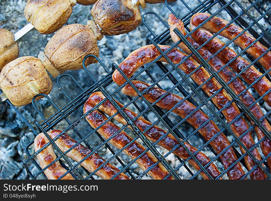 Grilled sausages and potato on barbecue. Grilled sausages and potato on barbecue