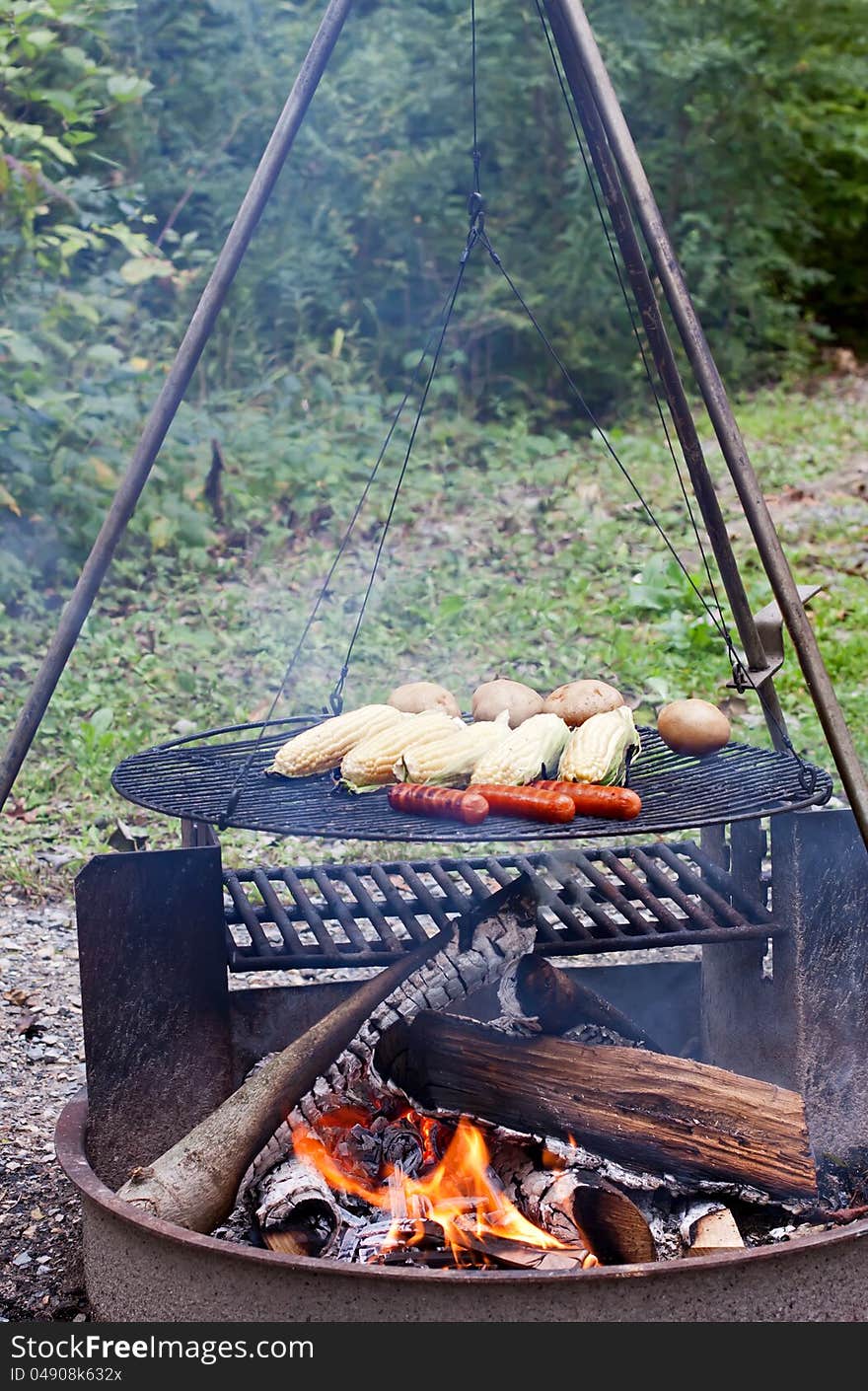 Hot dogs,corn and potatoes cooking on a grill at a Pennsylvania State Park. Hot dogs,corn and potatoes cooking on a grill at a Pennsylvania State Park.