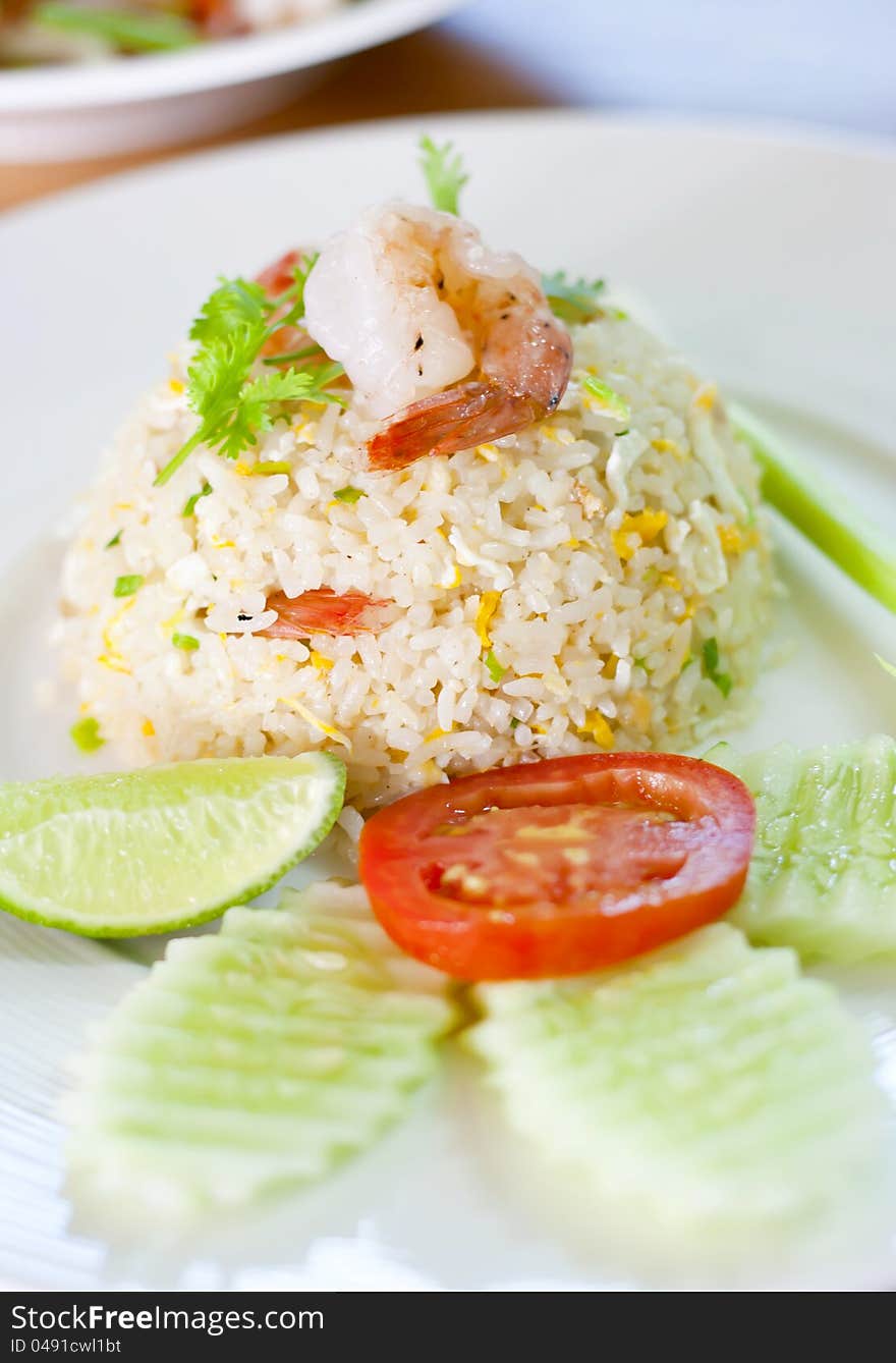 Shrimp fried rice on the dish with vegetables.